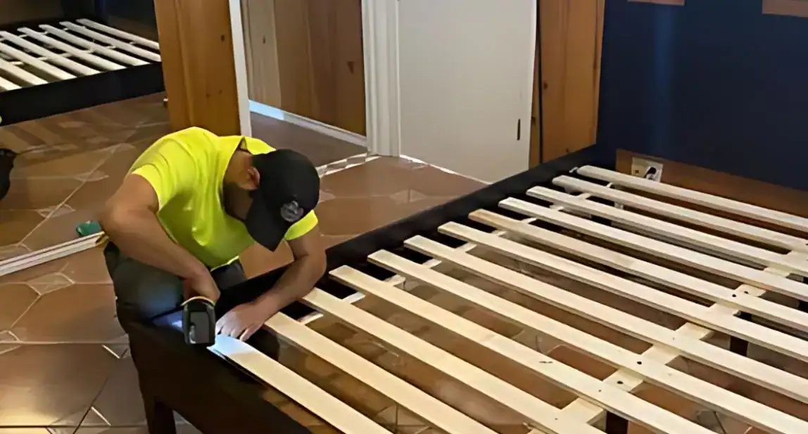 Furniture movers wrapping heavy pieces for transport